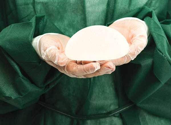 Surgeon holding breast implant